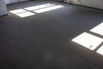 The leveled rough floor in a house under construction with a semi-dry cement screed is a smooth...