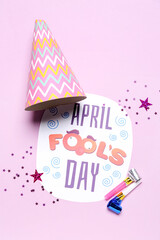 Composition with text APRIL FOOL'S DAY, party hat and whistles on color background
