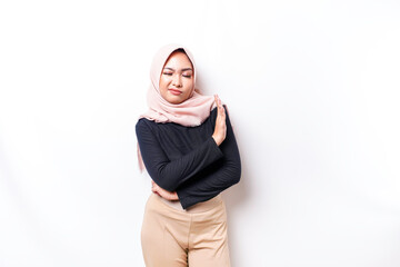 Beautiful Asian Muslim woman wearing a hijab with hand gesture pose rejection or prohibition with...