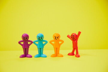 怒っている人と楽しそうなカラフルな人形