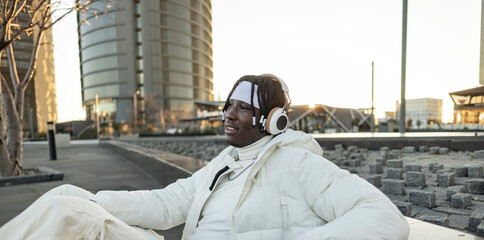 young african american man in the city listens to music with headphones