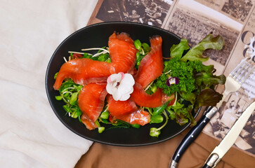 Healthy food meal cooked Fresh Salmon Salad served with Cucumber Roe and Lettuce bean sprouts Tomato garnished with salali and sesame oil sauce decorated with flowers