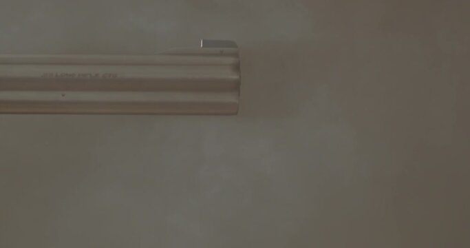Close up of revolver barrel shooting. Smoke blasts past the gun