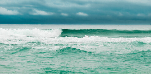 Obraz na płótnie Canvas Ocean wave with slightly cloudy sky