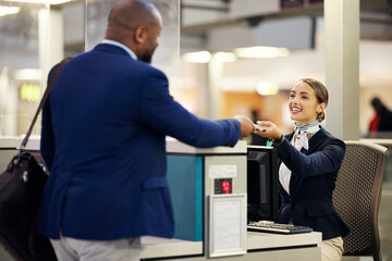 Businessman, airport and passenger assistant helping traveler with checkin at terminal counter. Black male with passport and service agent in travel help, security or immigration for airline control