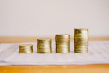 Stack of golden money coin on accounting sheet. Business and Financial concept. 