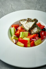 Greek salad with feta cheese and vegetables in a white plate