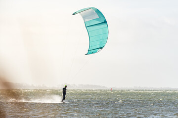 Kitesurfer with kite surfing on flat water on a sunny day