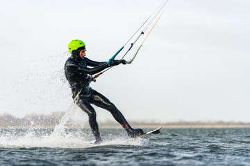 Kitesurfer starting out of the water with water running off