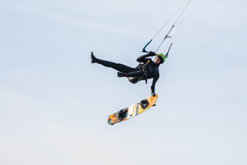 Fototapeta na wymiar Kitesurfer jumping and making a board off trick in the air