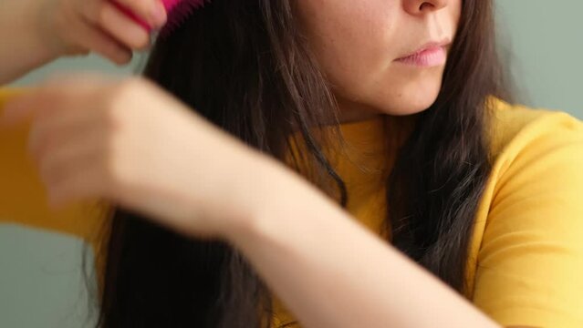 women holding messy hair in hands, Combing with brush and pulls long hair, Long disheveled hair