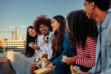 Multiethnic students have casual lunch outside.