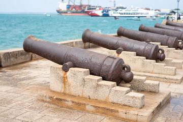 Cannons in Stone Town, Zanzibar, are a reminder of its dark history of slavery. These relics serve as a somber reminder of the island's past. - obrazy, fototapety, plakaty