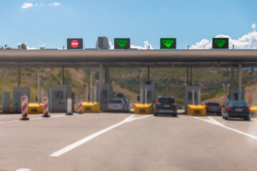 Cars passing through the point of toll highway, toll station. Highway toll gateway. Payment of the fare on the way.