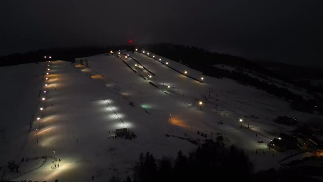 Aerial view of a ski slope in the Alps being prepared for night skiing. 