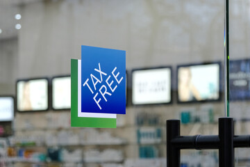 Taxfree logo sign on the glass door background of a store with goods.