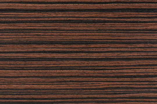 Macassar wood texture. High quality red and brown macassar wood plank surface texture. The texture of hard and heavy wood, with a beautiful surface for the production of furniture or flooring