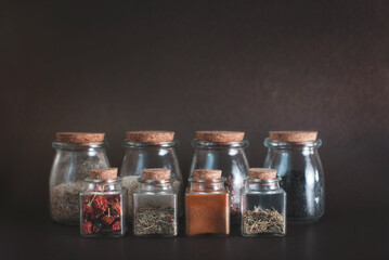 Set of different herbs and spice on a dark background.