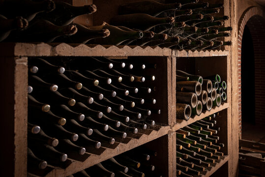 Resting bottles in dark wooden cellar