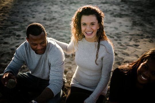 Wife smiles at camera as husband and step daughter look on