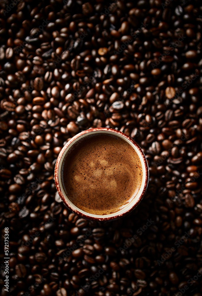 Wall mural Cup of coffee and dark roasted coffee beans