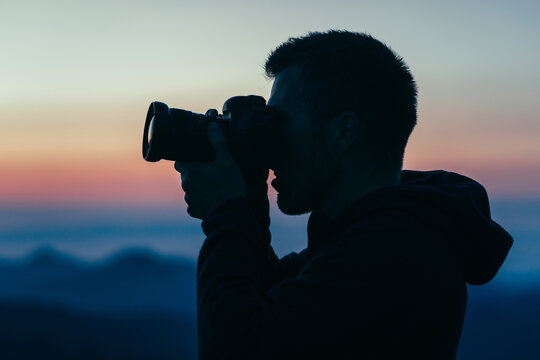 Man taking picture of purple sunset in Washington's National Park