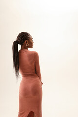 Fototapeta premium Back view shot of young and beautiful woman posing over white wall. Vertical.