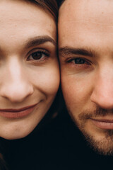 a close-up photo of the eyes of a man and a woman of brown color. a man and a woman leaned their faces together