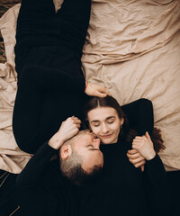 top view photo of a woman lying on a man's shoulder. black clothes a tender photo about the love of two people. love story. lie next to your beloved
