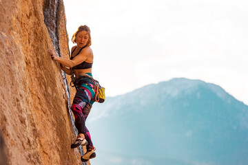 Fototapeta premium The sports girl is engaged in rock climbing