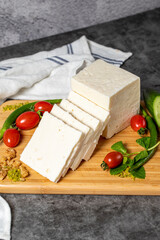 Ripe white cheese. Feta cheese made from cow's milk on a wooden serving board. Dairy products