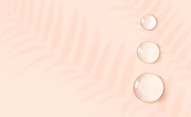 round drops of transparent gel serum on beige background