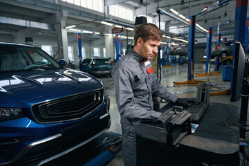 Fototapeta na wymiar Mechanic inspecting car system in the workshop
