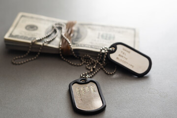 The soldier's military tokens are on dollar bills. Concept: cost of living soldier, military...