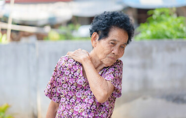 Sick senior adult elderly women touching the neck have shoulder and neck pain. Woman massaging her...