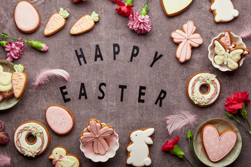 Easter aesthetic decorated cookies, aster flowers, feathers with Happy Easter text. Traditional spring background.