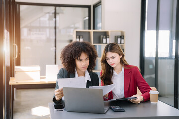 Business women or accountant working on laptop computer with business document, graph diagram and calculator on office table in office.