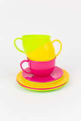 multi-colored plastic cups and plates on a white background kitchen set