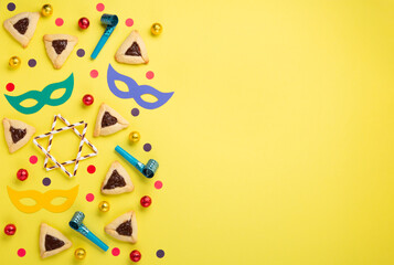 Hamantaschen Cookies, Carnival Mask, Noisemaker on Yellow Background. Purim Celebration, Jewish Carnival Holiday Concept.