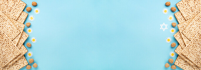 Passover greeting card with matzah, nuts, daisy and tulip flowers on blue background.