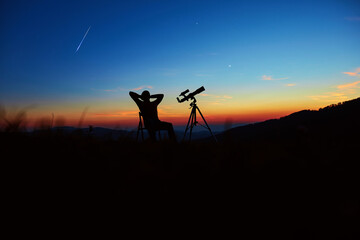 Fototapeta na wymiar Man with astronomy telescope looking at the night sky, stars, planets, Moon and shooting stars.
