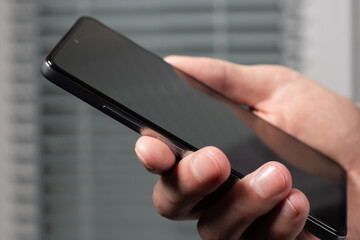 Touch screen smartphone, in hand. Man using smartphone