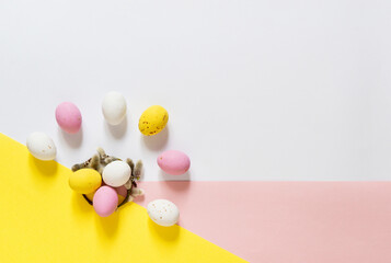 candy Easter eggs on a light white pink and yellow background. Happy easter flat lay. copy space	