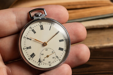 close up of hands with vintage pocket watch retro