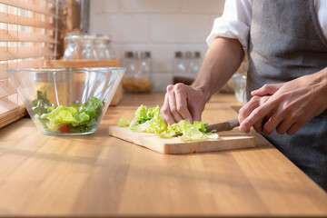 LGBT young couple heads into the kitchen to make a fruit and vegetable salad for the dinner meal.