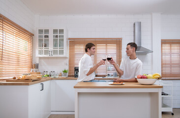 LGBT Young couple celebrate the day of love between each other with fine wine in the kitchen of the house