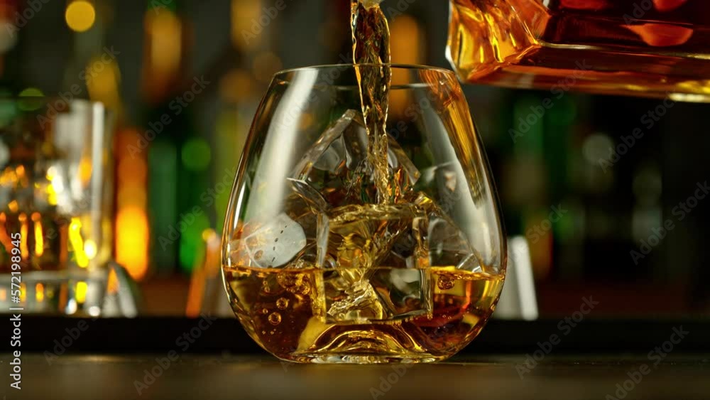 Poster super slow motion of falling ice cube into whiskey drink, camera motion. filmed on high speed cinema