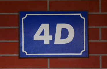Plate with house number 4 on brick wall