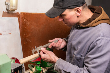 Work of a craftsman on a woodworking lathe in the workshop