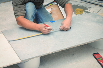 Worker making socket hole in tile indoors, closeup